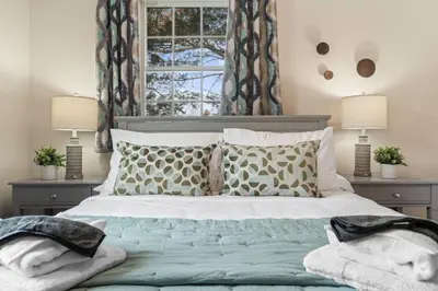 a bedroom with a bed with pillows and a window at Pine Cove Retreat - 4BR - Pool
