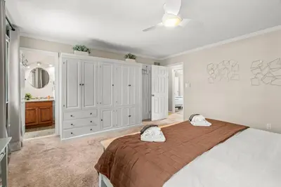 a bedroom with a large bed and a bathroom at Pine Cove Retreat - 4BR - Pool