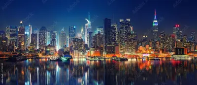 a night view of a large city with a harbor at Double Room at a shared Apartment near Times Square in New York