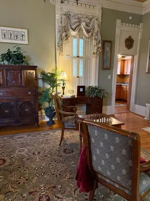 a living room with a table and a desk at The Stegmaier Mansion Guest House in Wilkes-Barre
