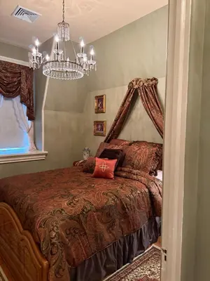 a bedroom with a bed and a chandelier at The Stegmaier Mansion Guest House in Wilkes-Barre