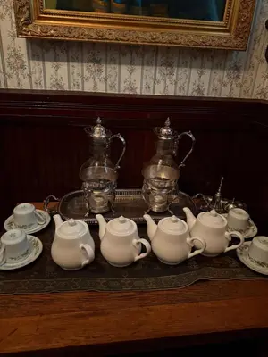 a group of tea sets on a table at The Stegmaier Mansion Guest House in Wilkes-Barre