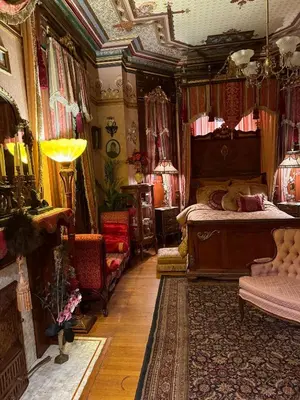 a bedroom with a bed and a couch in a room at The Stegmaier Mansion Guest House in Wilkes-Barre