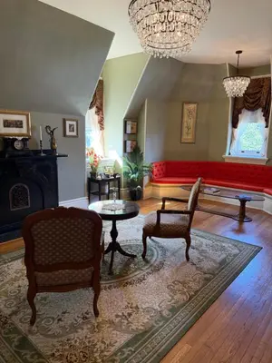 a living room with a couch and a table and chairs at The Stegmaier Mansion Guest House in Wilkes-Barre