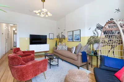a living room with a couch and chairs and a tv at The Blue Comfort & MINS to Newyork City with parking in Jersey City