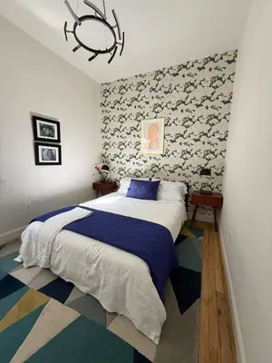 a bedroom with a large bed and a chandelier at The Blue Comfort & MINS to Newyork City with parking in Jersey City