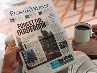 a person reading a newspaper with a cup of coffee at The Blue Comfort & MINS to Newyork City with parking in Jersey City