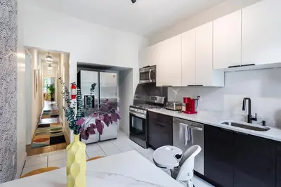 a kitchen with white cabinets and a table in a room at The Blue Comfort & MINS to Newyork City with parking in Jersey City