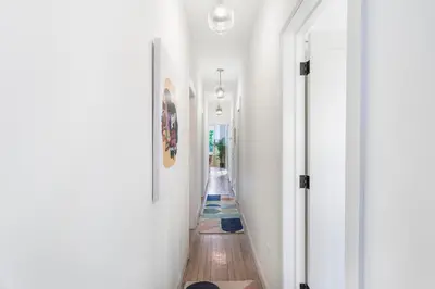 a hallway in a house with white walls and wood floors at The Blue Comfort & MINS to Newyork City with parking in Jersey City