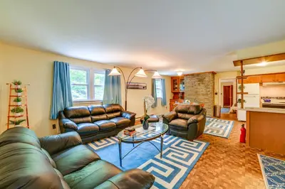 a living room with leather couches and a table at Serene Duplex with On-Site Brook in Callicoon Center in Roscoe
