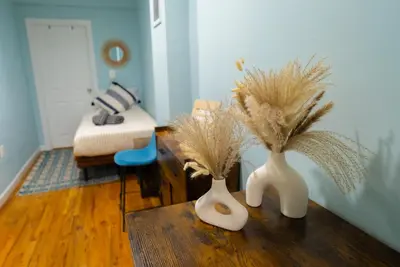 two white vases with dried plants on a table at Hells Kitchen Hideaway in New York