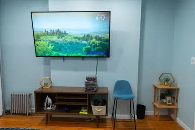 a living room with a flat screen tv on the wall at Hells Kitchen Hideaway in New York