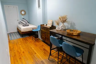 a room with a desk and chairs and a bed at Hells Kitchen Hideaway in New York