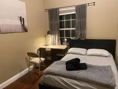 a bedroom with a bed and a desk and a window at Quiet apt only 15 mins from Midtown NYC in Jersey City