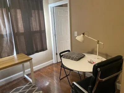 a room with a table and a lamp and a chair at Quiet apt only 15 mins from Midtown NYC in Jersey City