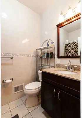 a bathroom with a toilet and a sink and a mirror at Quiet apt only 15 mins from Midtown NYC in Jersey City