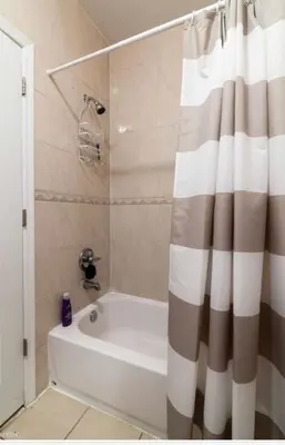 a bathroom with a tub and a shower curtain at Quiet apt only 15 mins from Midtown NYC in Jersey City