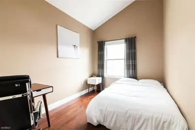 a bedroom with a bed and a desk and a window at Quiet apt only 15 mins from Midtown NYC in Jersey City