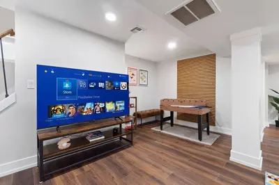 a living room with a flat screen tv and a pool table at NYC Edge Triplex Full House | Parking & Near Shops in North Bergen
