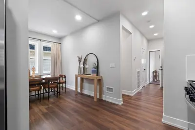a dining room and living room with a table and a mirror at NYC Edge Triplex Full House | Parking & Near Shops in North Bergen