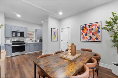 a kitchen and dining room with a wooden table and chairs at NYC Edge Triplex Full House | Parking & Near Shops in North Bergen