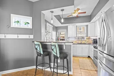 a kitchen with two bar stools and a ceiling fan at Fishtown Fun 2BR Fireplace in Philadelphia