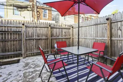 a table and chairs with an umbrella on a patio at Fishtown Fun 2BR Fireplace in Philadelphia