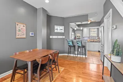 a dining room and kitchen with a wooden table and chairs at Fishtown Fun 2BR Fireplace in Philadelphia