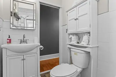a white bathroom with a toilet and a sink at Fishtown Fun 2BR Fireplace in Philadelphia