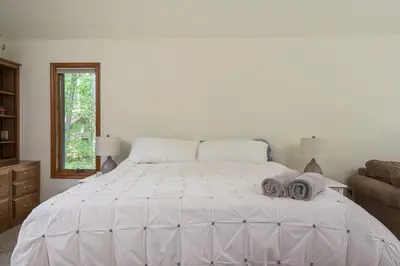 a bedroom with a large white bed with towels on it at Pocono Escape Style and Serenity in Pocono Pines
