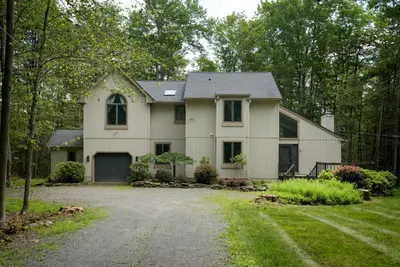a large white house with a driveway at Pocono Escape Style and Serenity in Pocono Pines