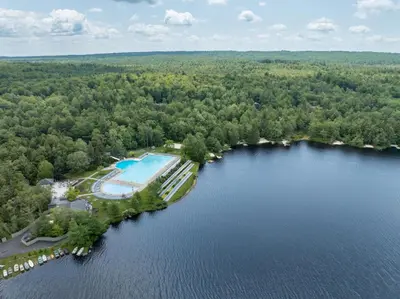 an aerial view of a lake with a swimming pool at Pocono Escape Style and Serenity in Pocono Pines