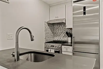 a kitchen with a sink and a stainless steel refrigerator at Washington Square West - Unit A in Philadelphia