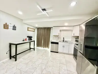 a kitchen with white cabinets and a table in it at Historic Barn View Modern Country Newton House in Newton