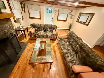 a living room with a couch and a fireplace at Country Comfort Cabin Delaware River Islands in Montague