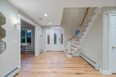 a hallway with white walls and wooden floors and stairs at Huge Retreat w Alaska King, Pool & Jacuzzi Tub Indoor in Goshen