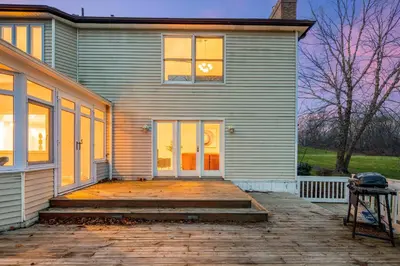 a house with a wooden porch and a door at Huge Retreat w Alaska King, Pool & Jacuzzi Tub Indoor in Goshen