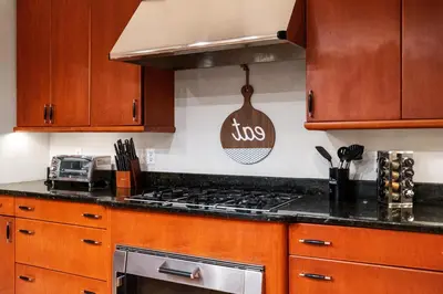 a kitchen with wooden cabinets and a stove top oven at Huge Retreat w Alaska King, Pool & Jacuzzi Tub Indoor in Goshen