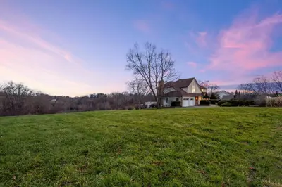 a house in the middle of a grassy field at Huge Retreat w Alaska King, Pool & Jacuzzi Tub Indoor in Goshen