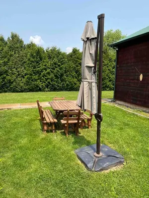 a picnic table with an umbrella and a table and benches at Starboat Log Home in Jersey Shore
