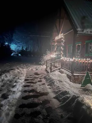 a house decorated with christmas lights in the snow at Starboat Log Home in Jersey Shore