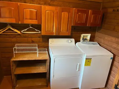 a kitchen with a refrigerator and a washer at Starboat Log Home in Jersey Shore