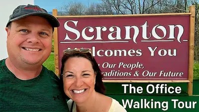 a man and a woman standing in front of a sign at NEW 