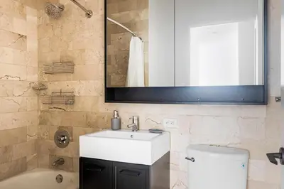 a bathroom with a sink and a toilet and a mirror at Blueground Financial District rooftop nr Brooklyn Bridge NYC-1971 in New York