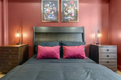 a bedroom with a bed with pink pillows and two night stands at Brewerytown Luxurious Home Movie theater in Philadelphia