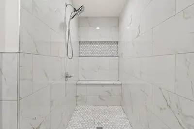 a white bathroom with a shower with a shower at Brewerytown Luxurious Home Movie theater in Philadelphia