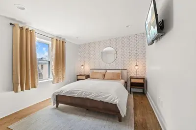a bedroom with a bed and a tv on a wall at Brewerytown Luxurious Home Movie theater in Philadelphia