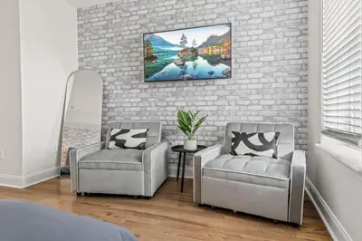 a bedroom with two chairs and a brick wall at Brewerytown Luxurious Home Movie theater in Philadelphia