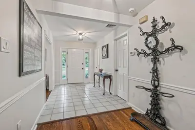 a hallway with white walls and a white tile floor at New Pristine Suburban Escape in Newtown Square
