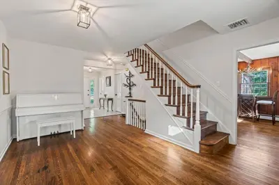 a living room with a staircase and a piano at New Pristine Suburban Escape in Newtown Square